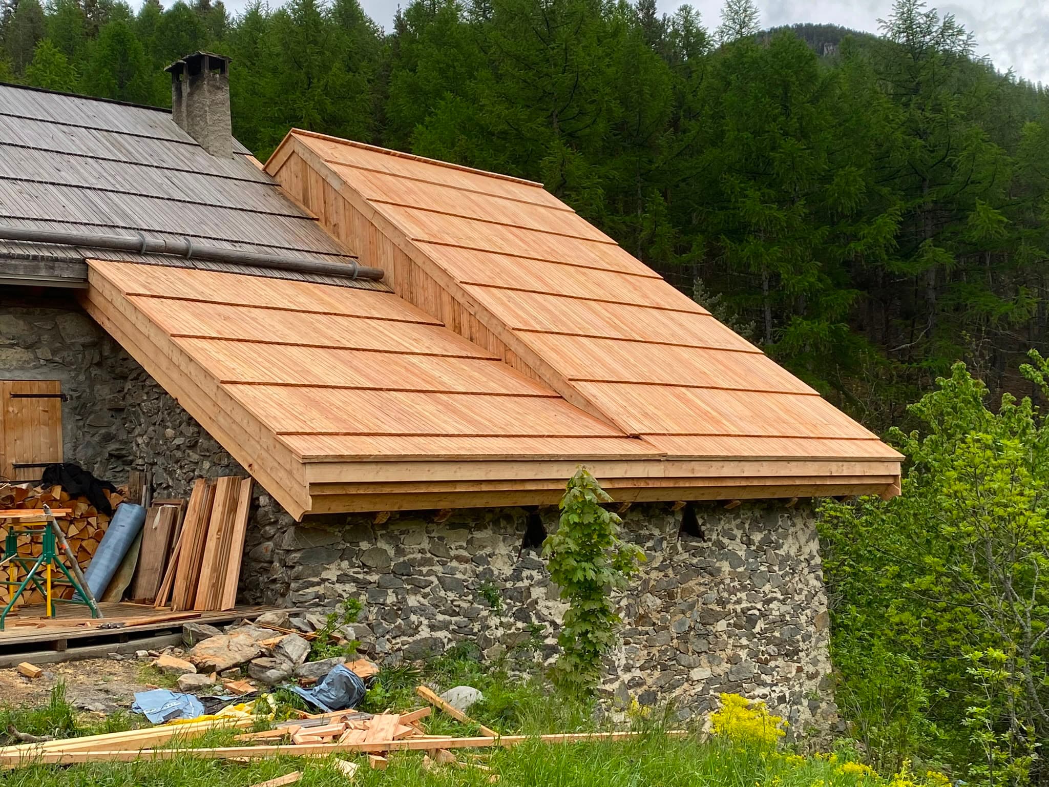 Toiture en bardeaux de bois neuve sur une bâtisse ancienne en pierre
