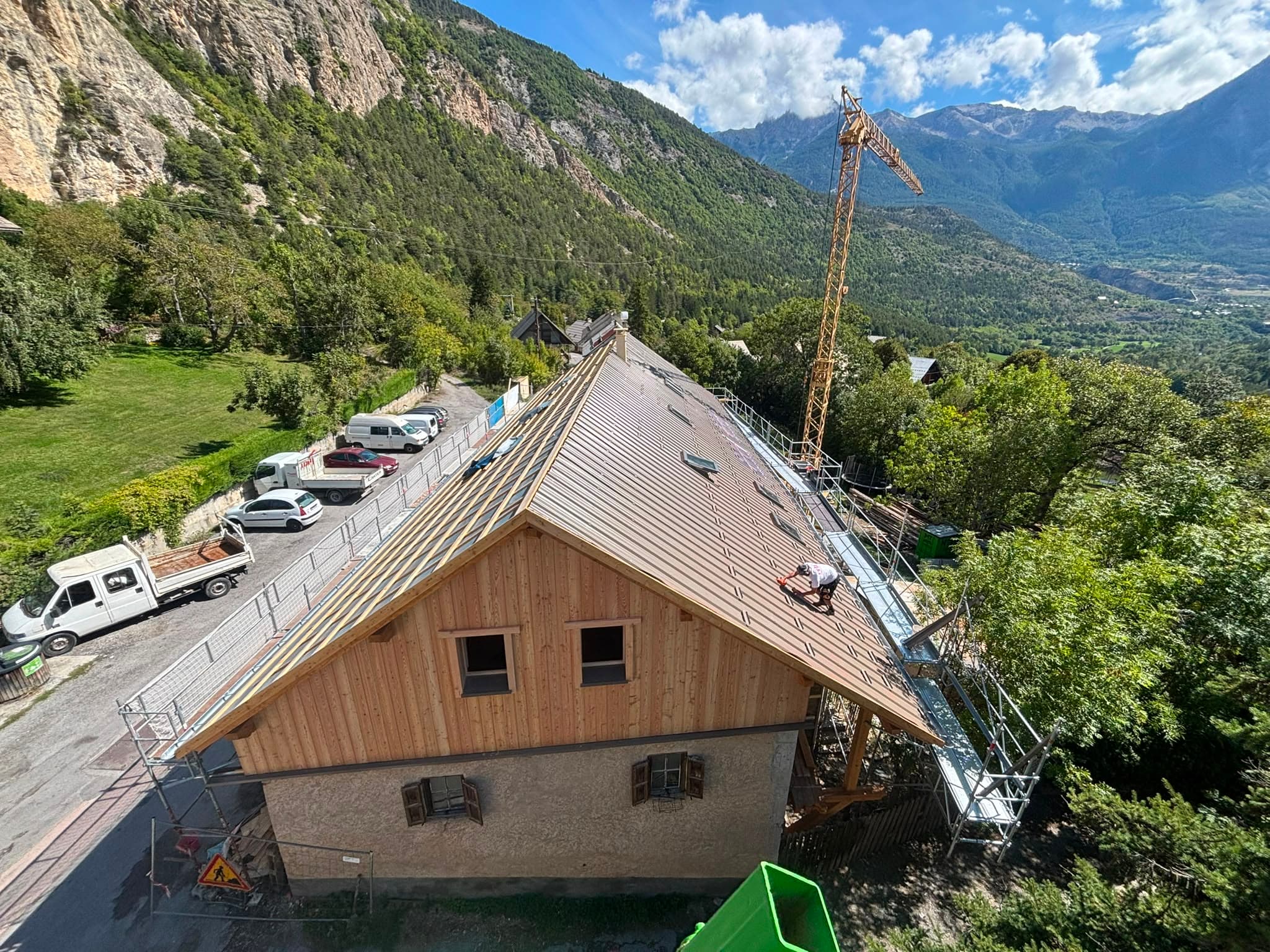 Pose de toiture en cours, vue aérienne sur un chantier de village