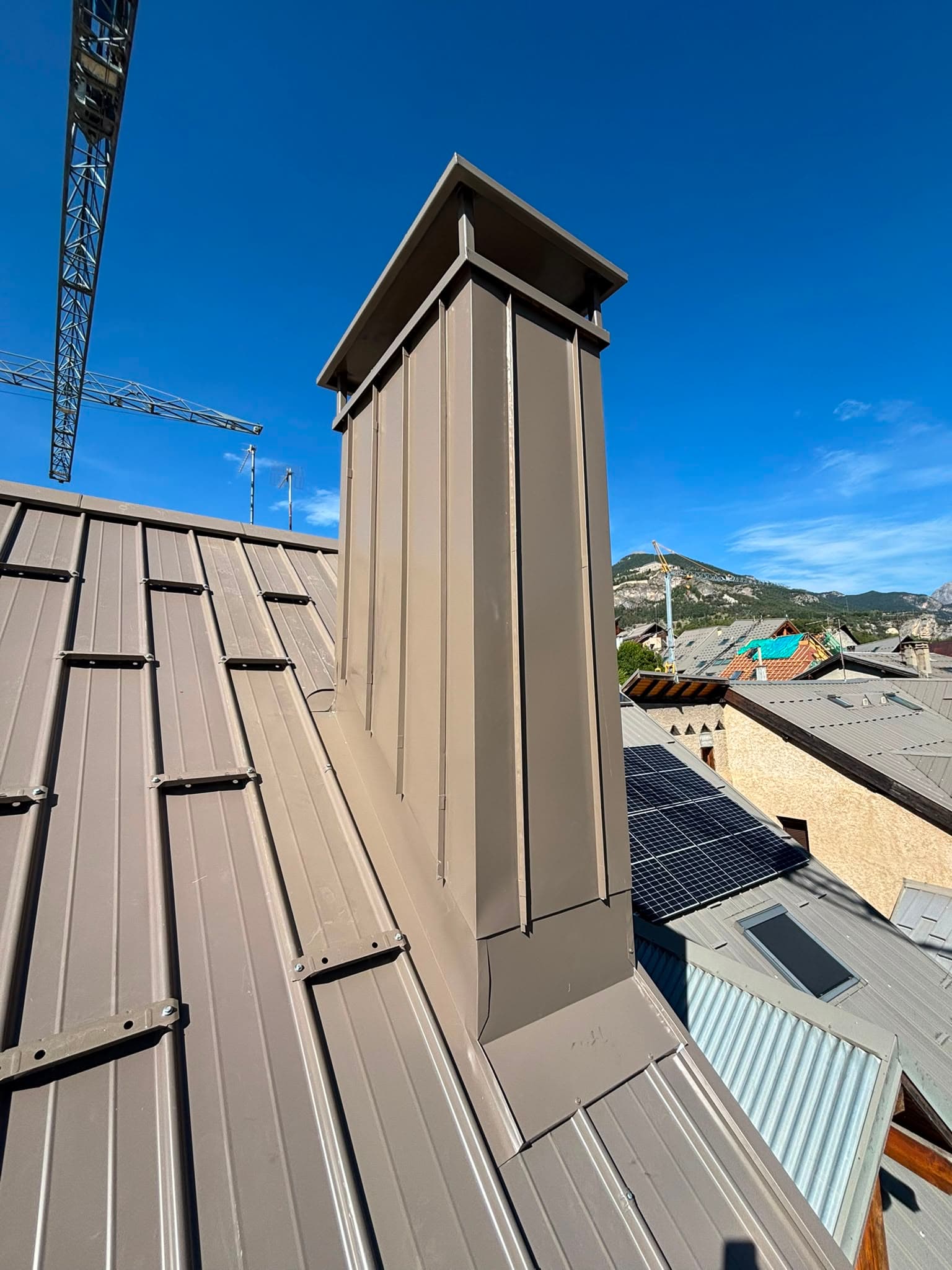 Souche de cheminée en zinguerie avec vue aérienne sur le village