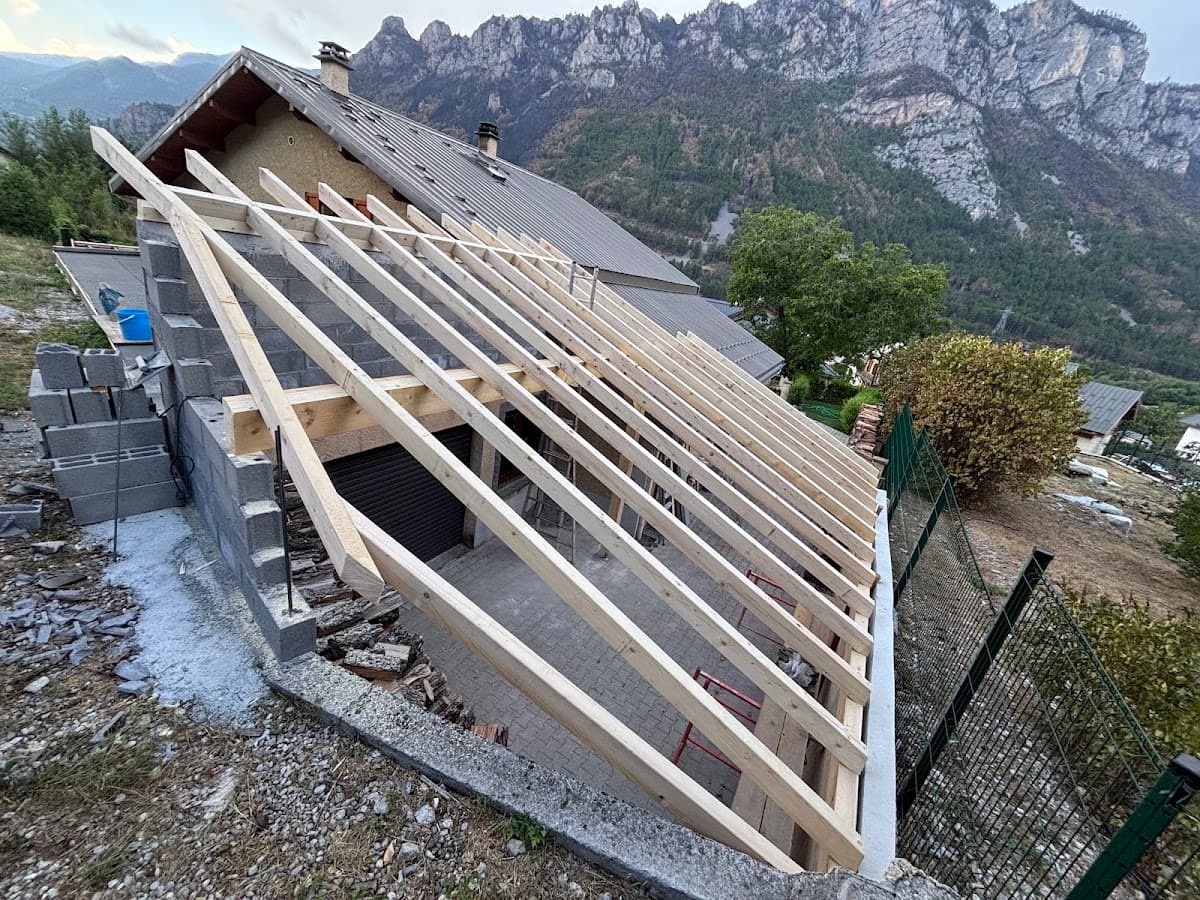 Extension de toiture en cours de charpente sur un chalet